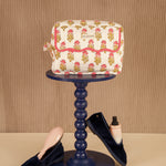 Petite trousse de toilette N°50 Rose sur un guéridon, mocassins en velours au sol