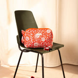 Petite trousse de toilette Antioche Tomato sur une chaise vert foncé, ballerines rouges