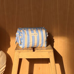 Petite trousse à volants Pacha Bleu ciel posée sur un tabouret en bois