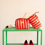 Petite trousse volants et trousse à crayons Pacha Tomato sur une étagère verte, ballerines rouges