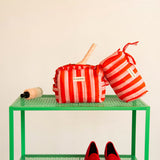Petite trousse volants et trousse à crayons Pacha Tomato sur une étagère verte, ballerines rouges