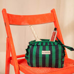 Petite trousse volants Pacha Menthe avec pinceaux, posée sur une chaise orange