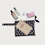 Pochette plate Léopard Bleu marine posée avec parfum, poudrier et carnet
