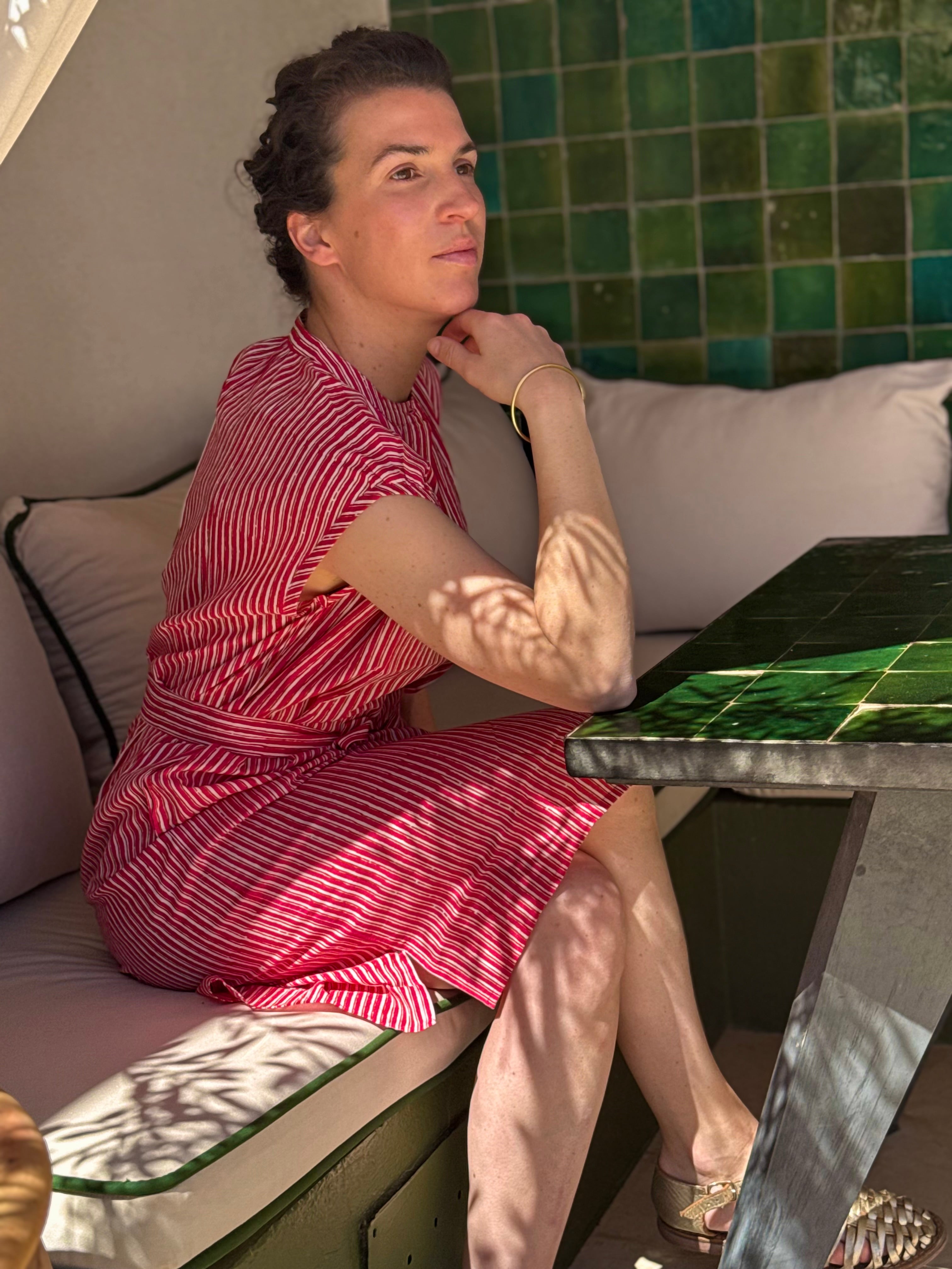 Robe Charlotte Fraise portée, femme assise accoudée à une table carrelée
