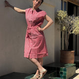 Robe Charlotte Fraise portée sur une terrasse, bras tendu