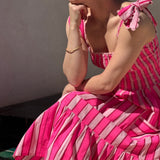 Robe Froufrou Fluo Pink portée, femme assise accoudée sur une terrasse