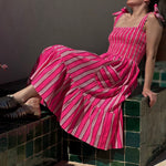 Robe Froufrou Fluo Pink portée, femme assise sur un banc en carreaux verts