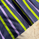 Gros plan sur les rayures marine, lilas et vert fluo de la robe Liberty