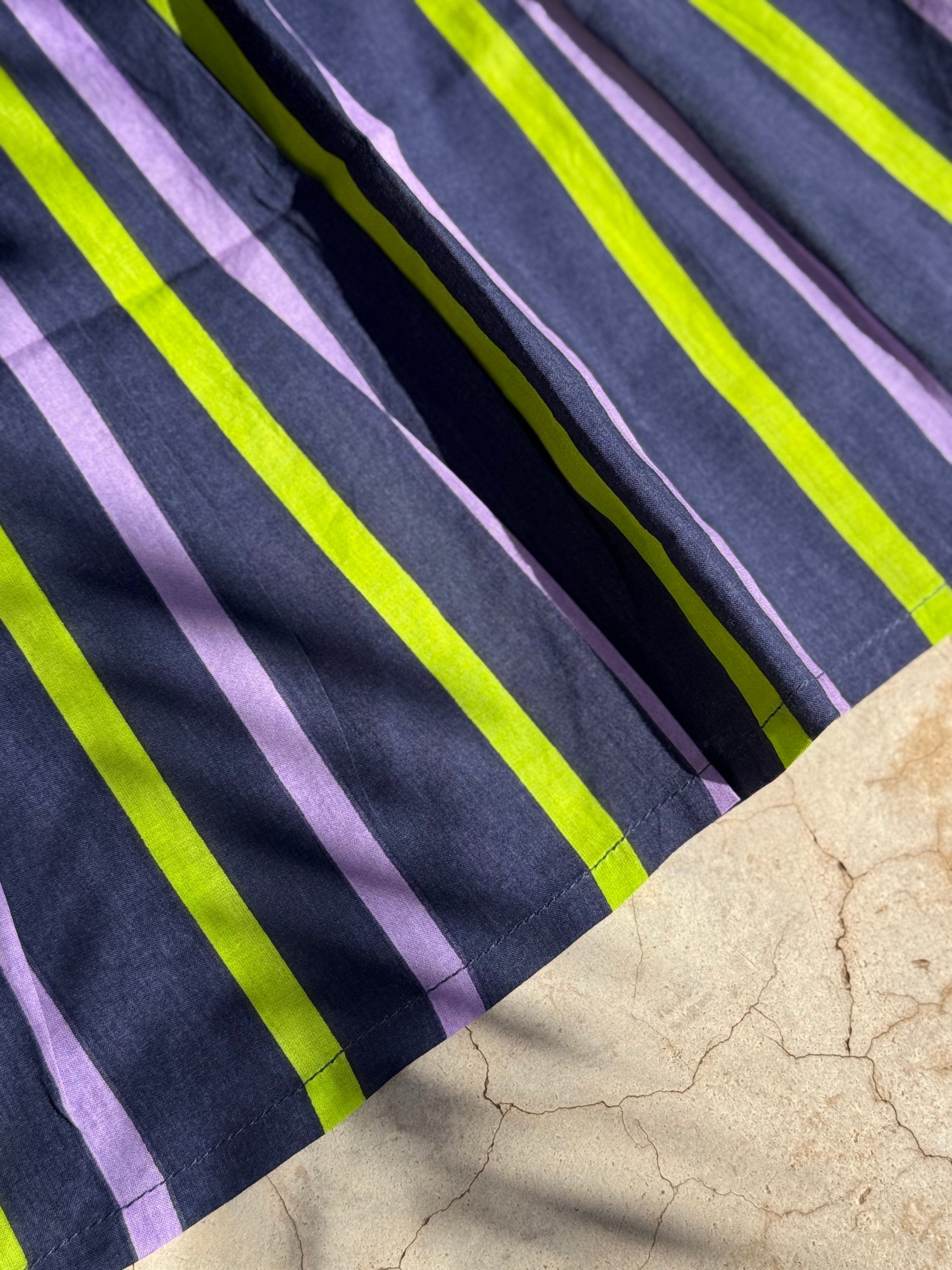 Gros plan sur les rayures marine, lilas et vert fluo de la robe Liberty