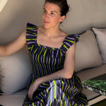 Robe Liberty Navy Fluo portée, femme assise sur un canapé