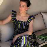 Robe Liberty Navy Fluo portée, femme assise sur un canapé