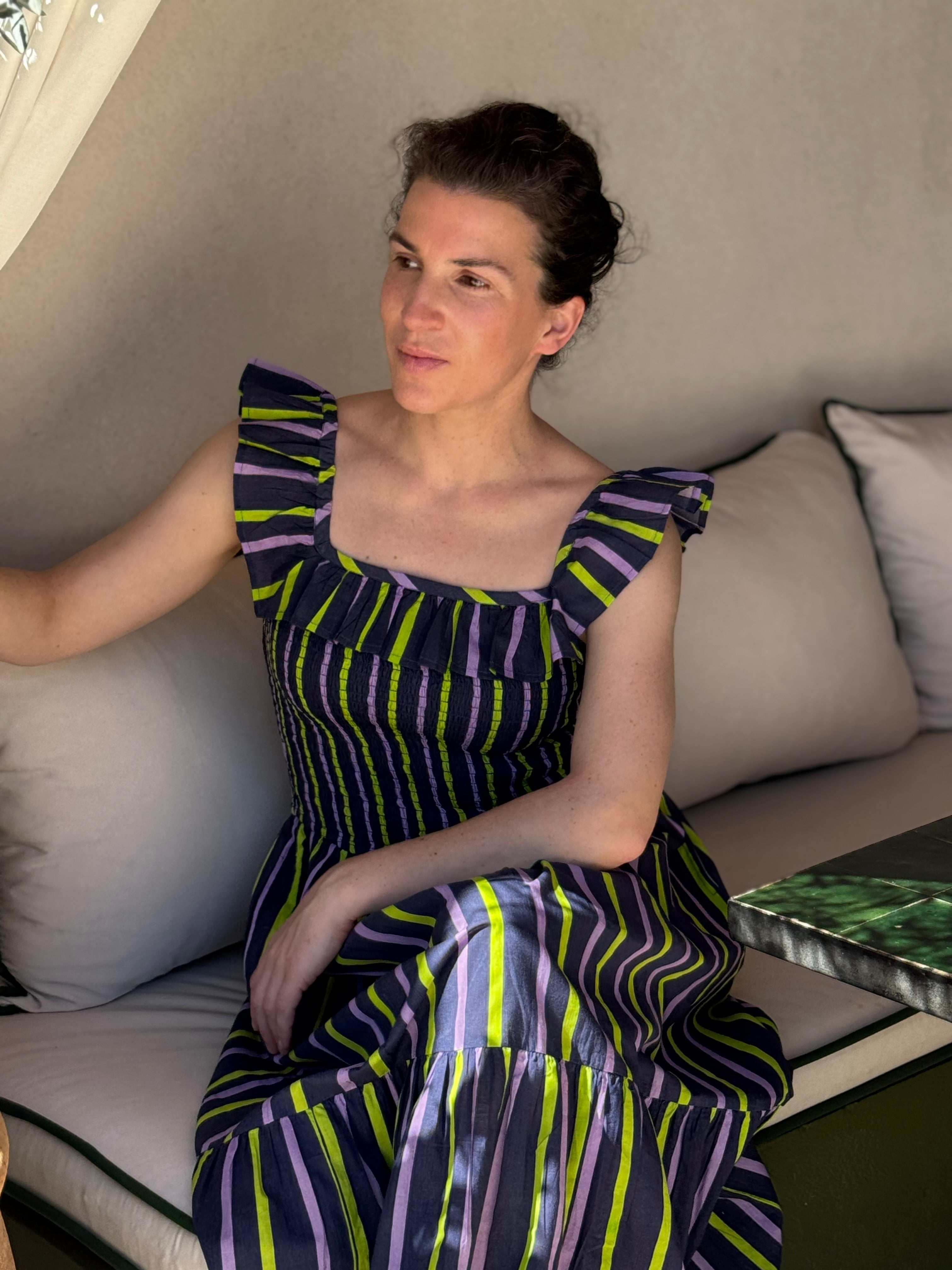Robe Liberty Navy Fluo portée, femme assise sur un canapé