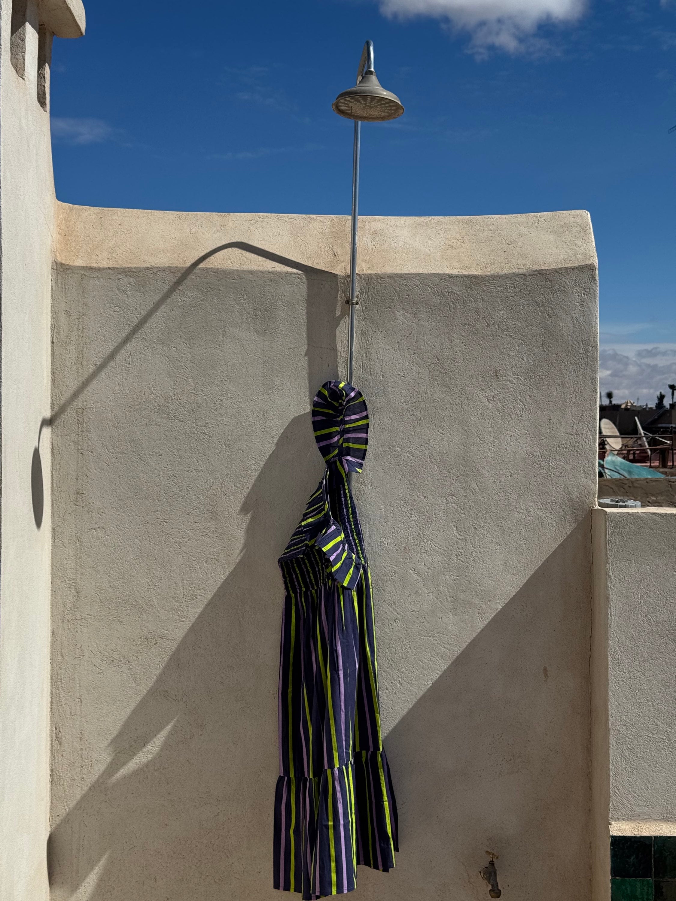 Robe Liberty Navy Fluo suspendue à une douche extérieure