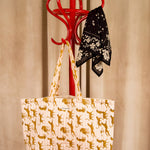 Sac cabas Fauve Rose de Byzantine, guépards ocre, suspendu à un porte-manteau rouge