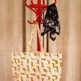 Sac cabas Fauve Rose de Byzantine, guépards ocre, suspendu à un porte-manteau rouge