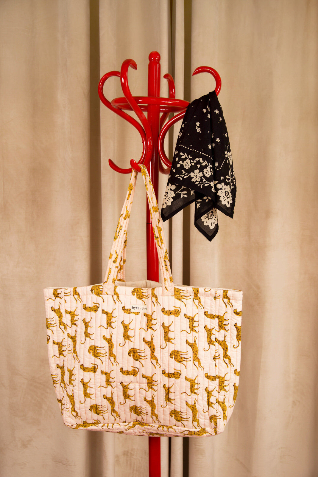 Sac cabas Fauve Rose de Byzantine, guépards ocre, suspendu à un porte-manteau rouge