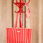 Sac cabas Pacha Tomato, rayures rouge et rose, suspendu à un porte-manteau rouge