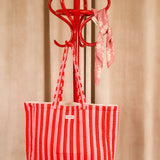 Sac cabas Pacha Tomato, rayures rouge et rose, suspendu à un porte-manteau rouge