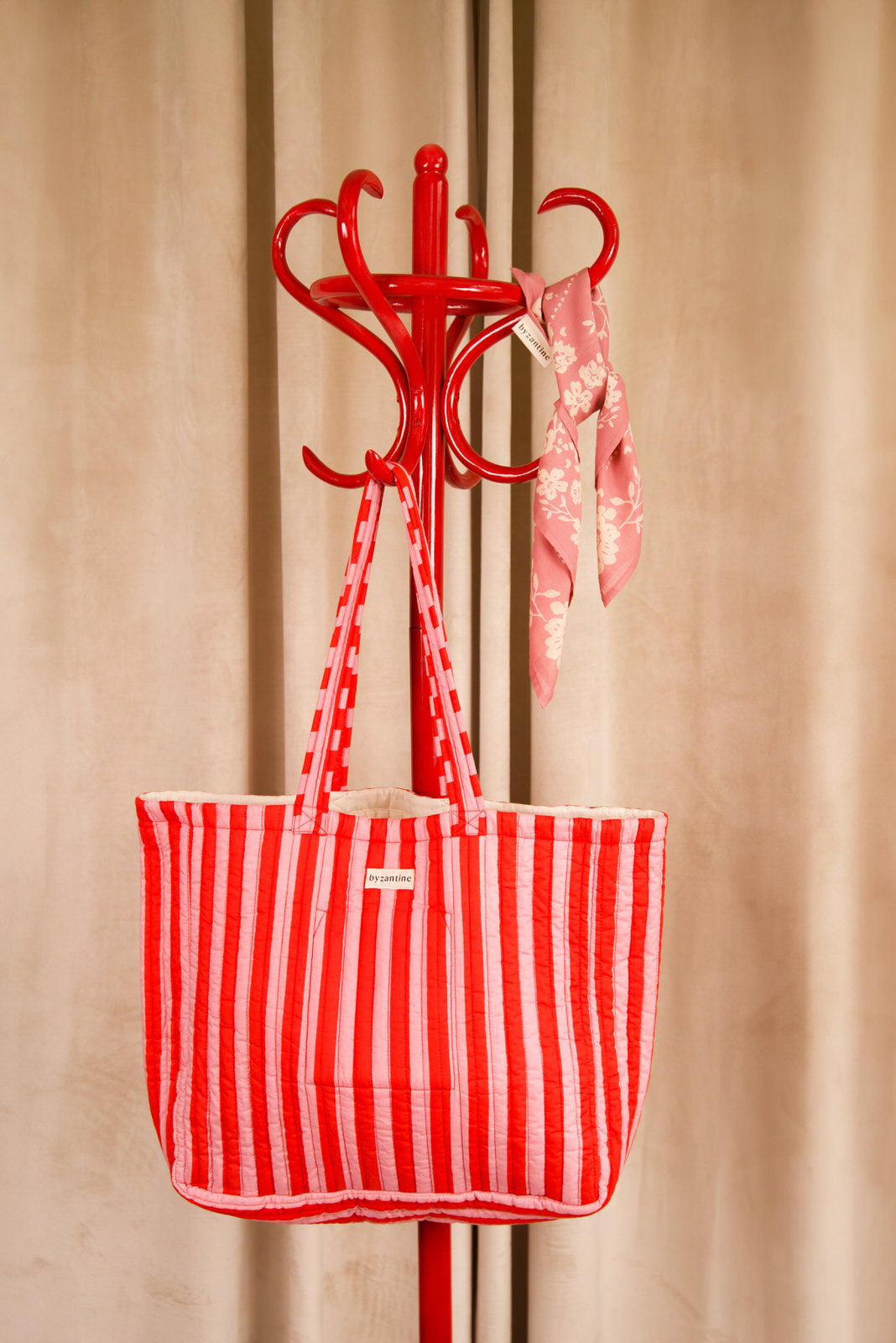 Sac cabas Pacha Tomato, rayures rouge et rose, suspendu à un porte-manteau rouge