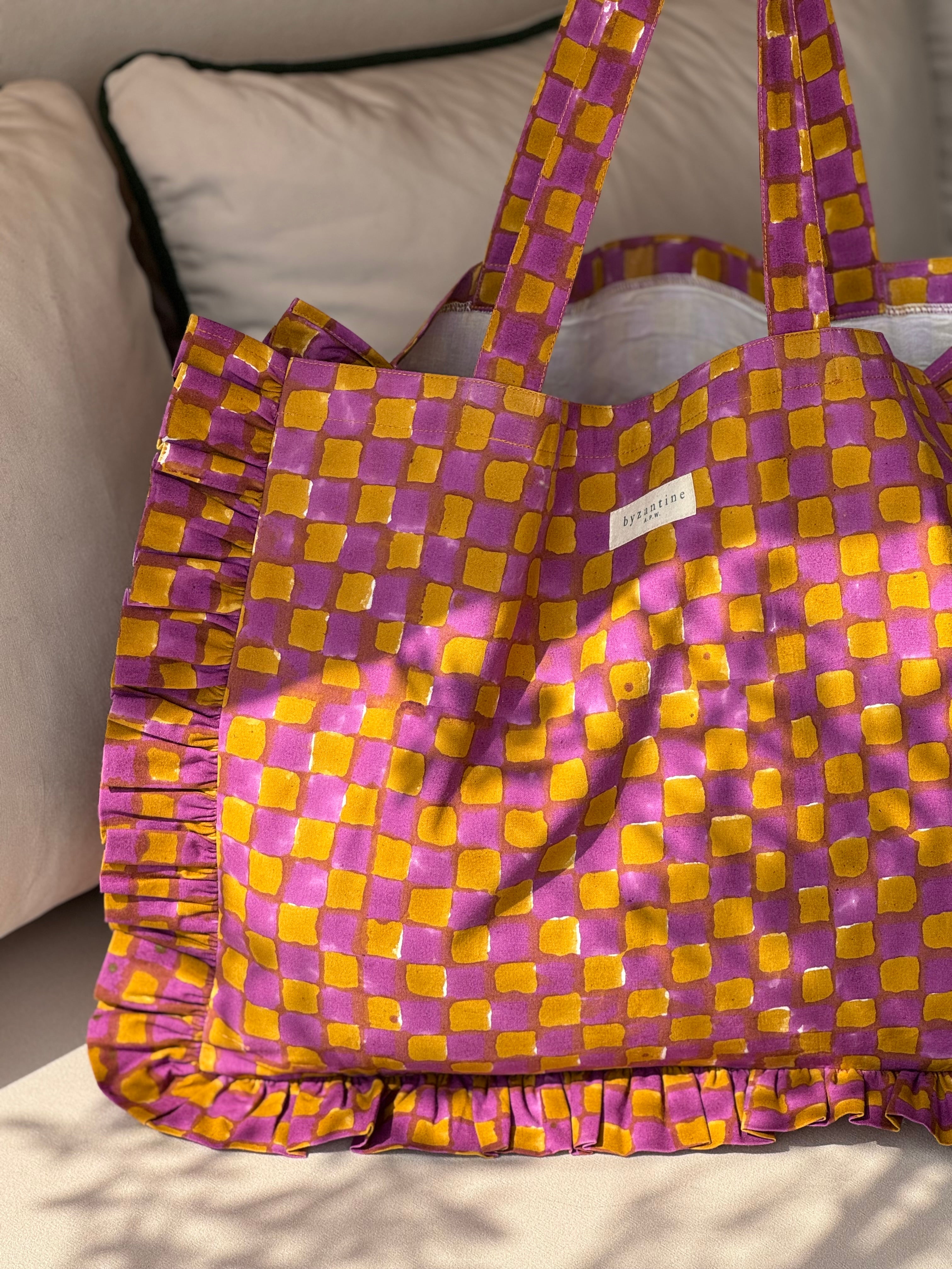 Sac froufrou Moutarde violet de trois quarts, doublure blanche visible, volants à damier