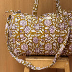 Sac weekend Carthage Kaki suspendu, fleurs lilas et blanches sur fond kaki, étiquette Byzantine