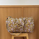 Sac weekend Carthage Kaki posé sur un tabouret, coton matelassé fleuri kaki
