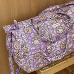 Sac weekend Carthage Lilas sur un tabouret, fleurs écrues sur fond lilas, anses longues