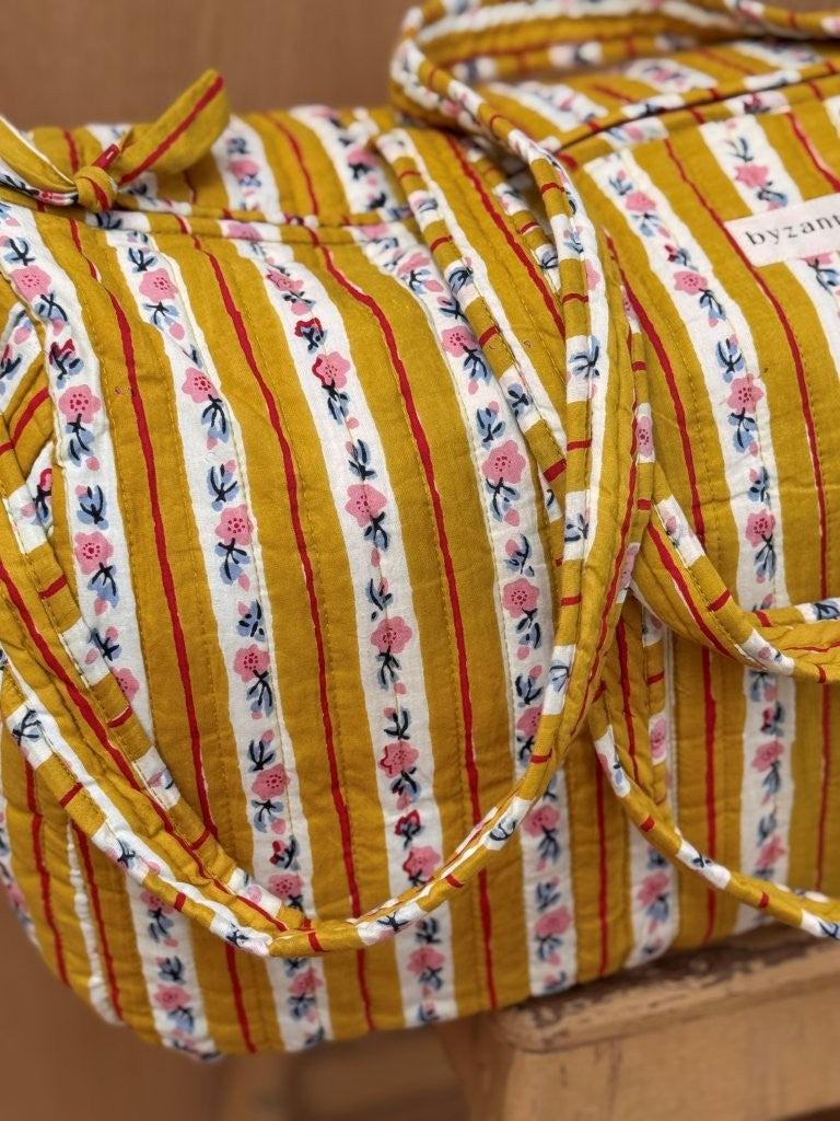 Gros plan sur le sac weekend Flora Passion, anses nouées, rayures moutarde fleuries