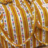 Gros plan sur le sac weekend Flora Passion, anses nouées, rayures moutarde fleuries
