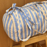 Sac weekend Pacha Bleu ciel posé sur un tabouret, larges rayures bleu ciel et écru