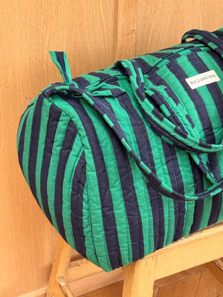 Sac weekend Pacha Menthe sur un tabouret, larges rayures vert menthe et bleu nuit