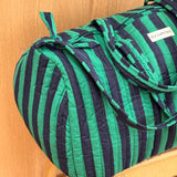 Sac weekend Pacha Menthe sur un tabouret, larges rayures vert menthe et bleu nuit