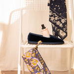 Trousse à crayons N°113 Bleu posée contre une chaise blanche, mocassins et foulard
