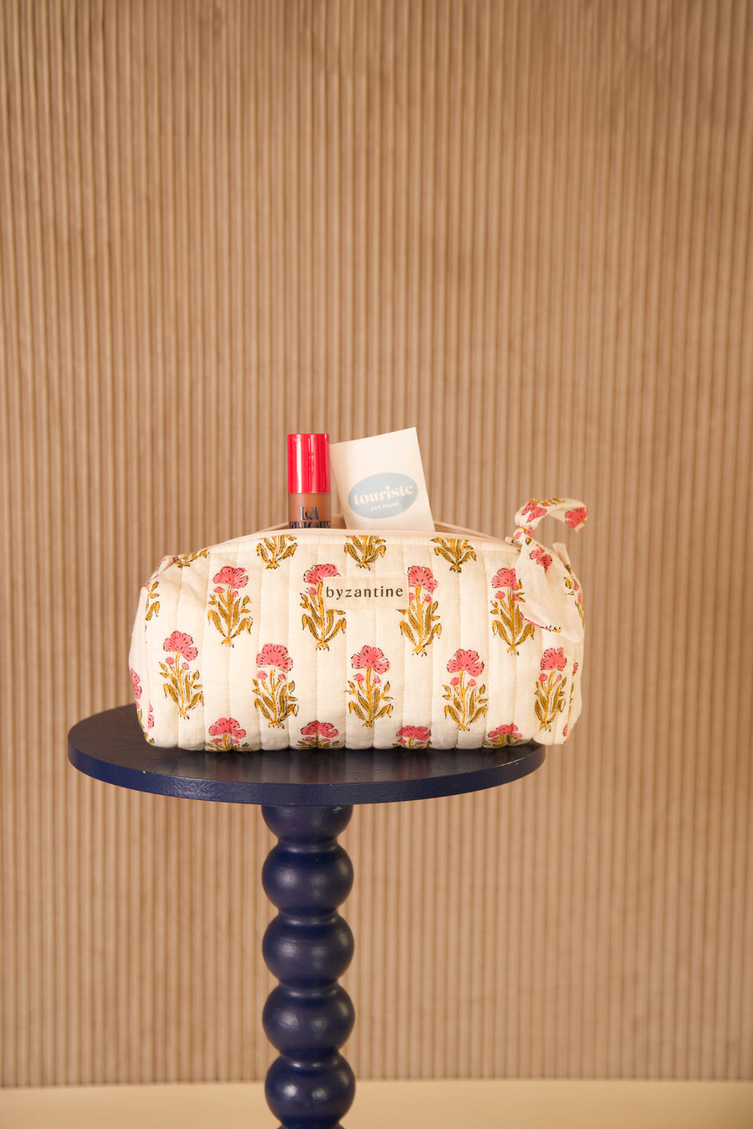 Trousse à crayons N°50 Rose à liseré rose, posée sur un guéridon bleu marine