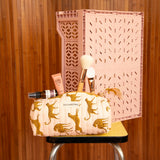 Trousse à crayons Fauve Rose avec pinceaux, sur un tabouret devant une caisse rose