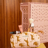 Gros plan sur la trousse à crayons Fauve Rose, guépards ocre sur fond rose pâle