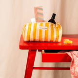 Trousse à crayons Pacha Passion avec peigne et flacon, sur une table rouge