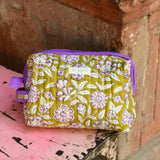 Trousse de toilette XL Carthage Kaki posée sur un banc, étiquette Byzantine et passepoil violet