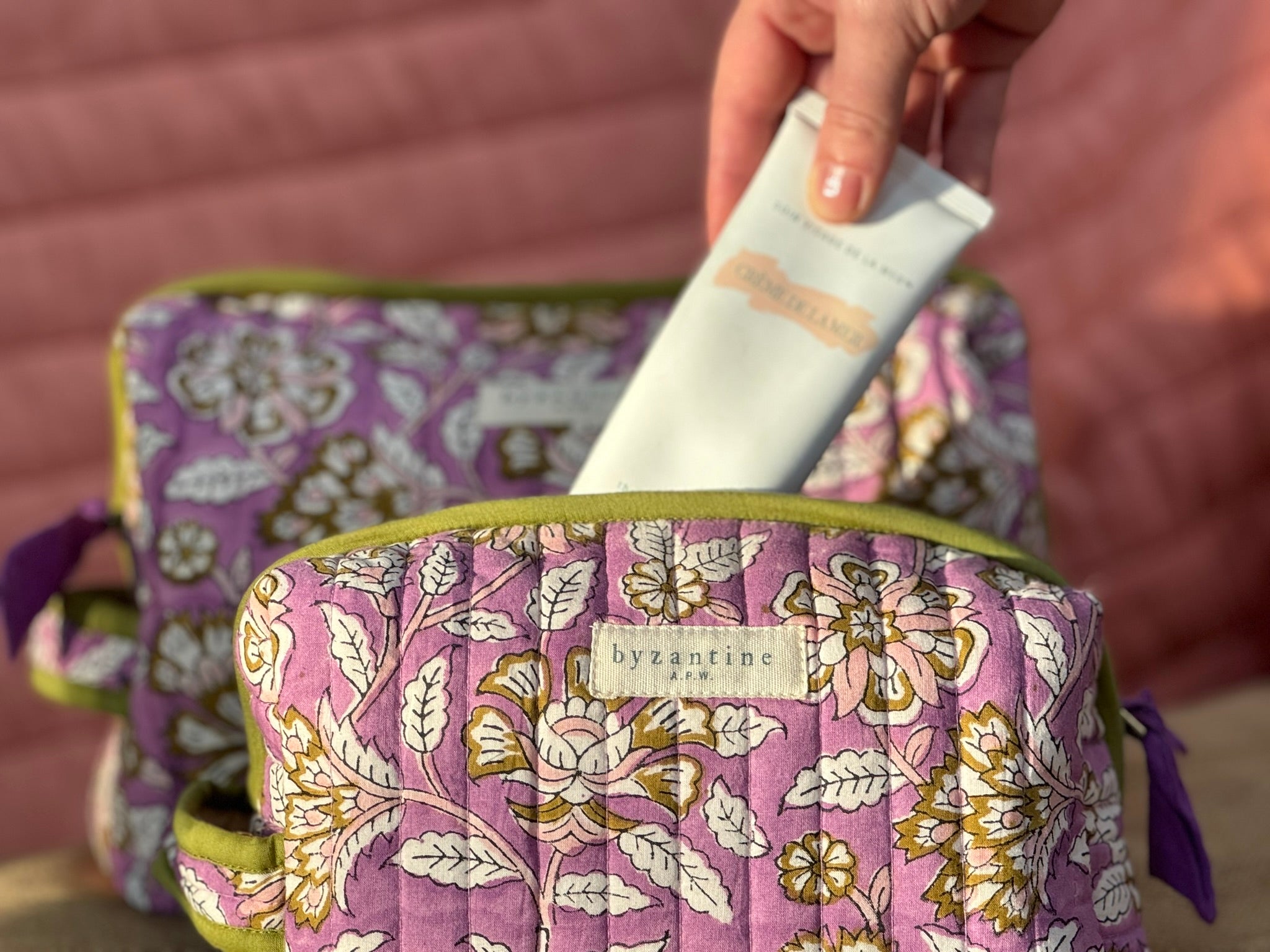 Tube de crème rangé dans la petite trousse de toilette Carthage Lilas, coton matelassé fleuri lilas