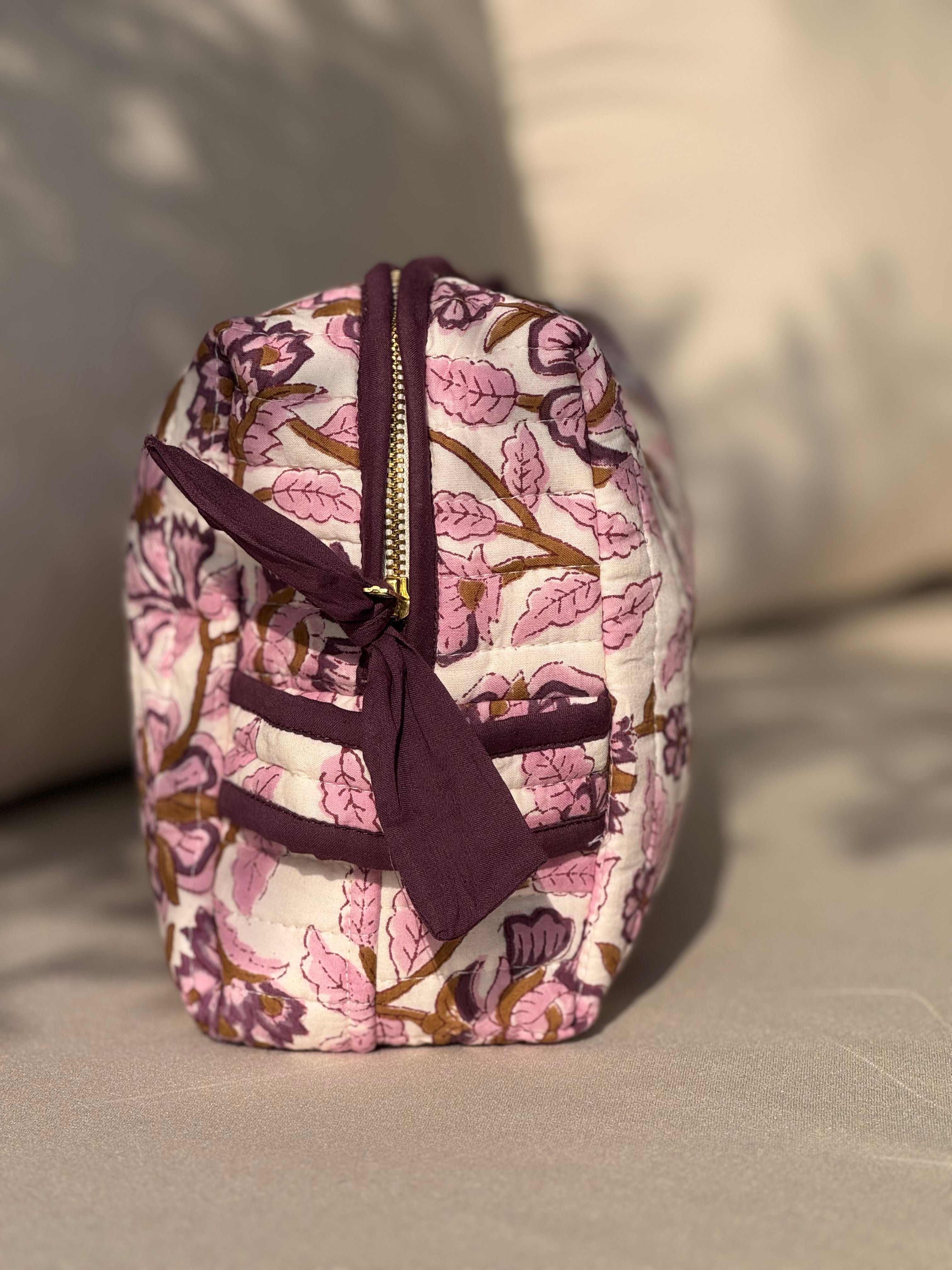 Trousse de toilette XL Carthage Prune de côté sur un canapé, poche latérale et nœud prune