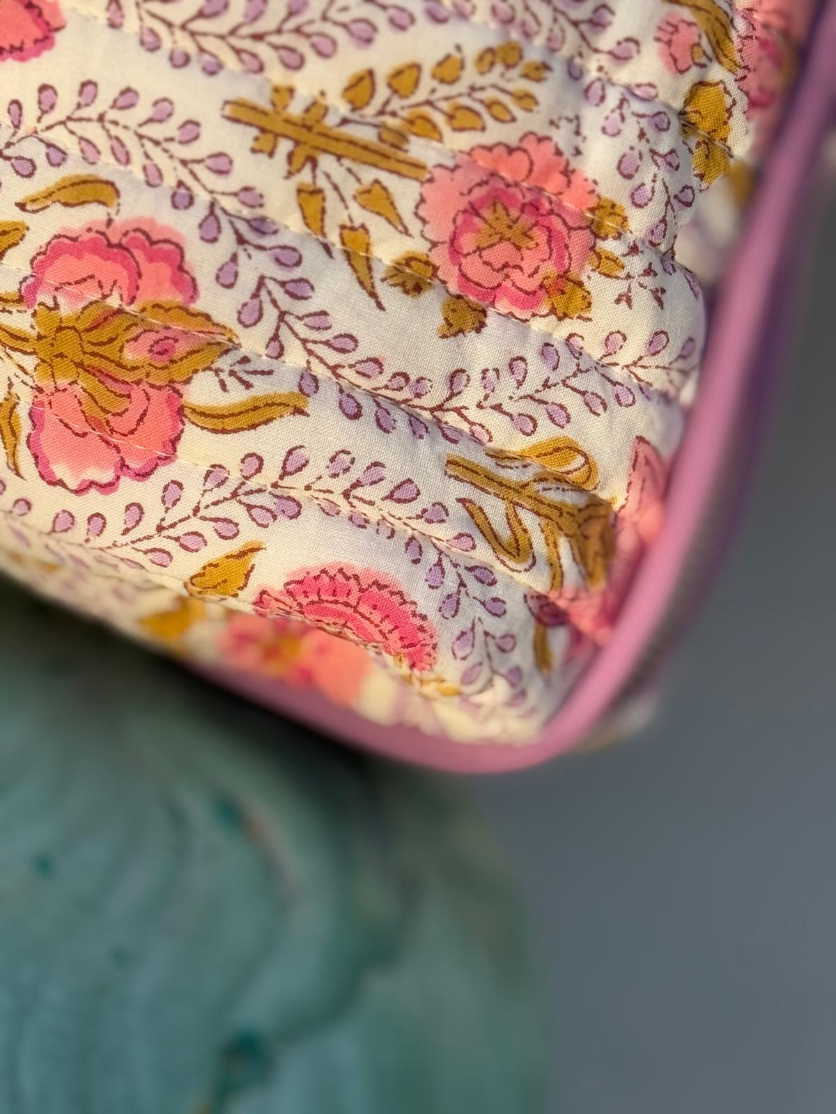Gros plan sur l'imprimé fleuri Éphèse Rose, roses corail et rinceaux lilas, bord passepoilé