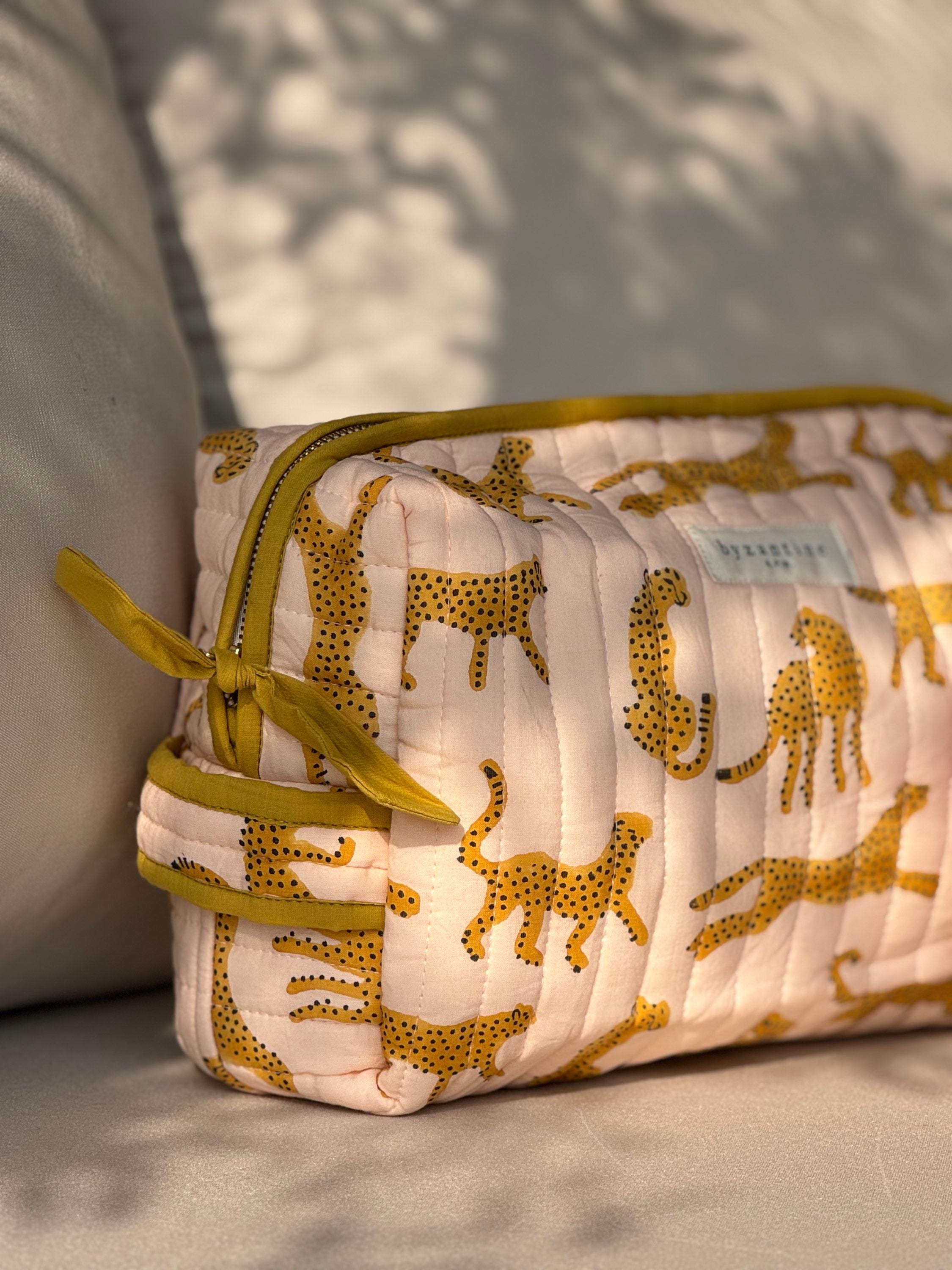 Trousse de toilette XL Fauve Rose, guépards ocre sur coton matelassé rose pâle, nœud de zip moutarde
