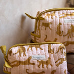 Trousses de toilette XL Fauve Rose empilées, étiquette Byzantine sur le coton matelassé