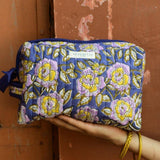 Trousse de toilette XL N°113 Bleu tenue à la main, fleurs lilas et jaunes sur fond bleu