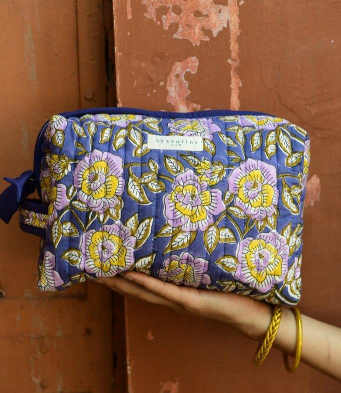 Trousse de toilette XL N°113 Bleu tenue à la main, fleurs lilas et jaunes sur fond bleu