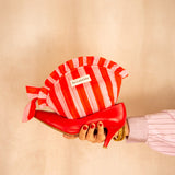 Trousse froufrou Pacha Tomato tenue à la main, rayures rouge et rose