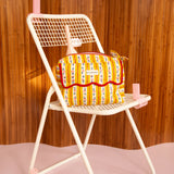 Trousse rabat Flora Passion à bord festonné rouge, posée sur une chaise pliante blanche