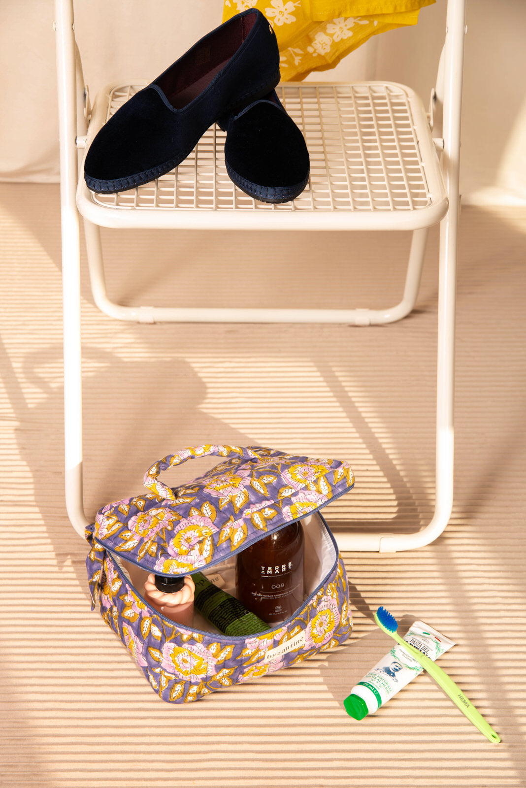 Trousse vanity N°113 Bleu ouverte au sol, avec des soins et du dentifrice