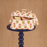 Trousse vanity N°50 Rose ouverte sur un guéridon bleu marine