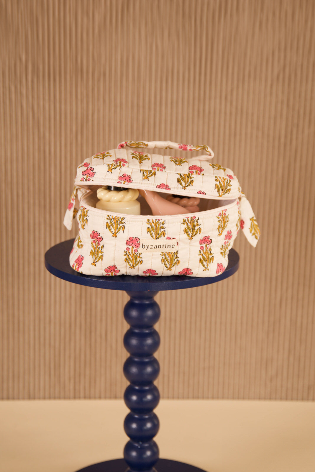 Trousse vanity N°50 Rose ouverte sur un guéridon bleu marine